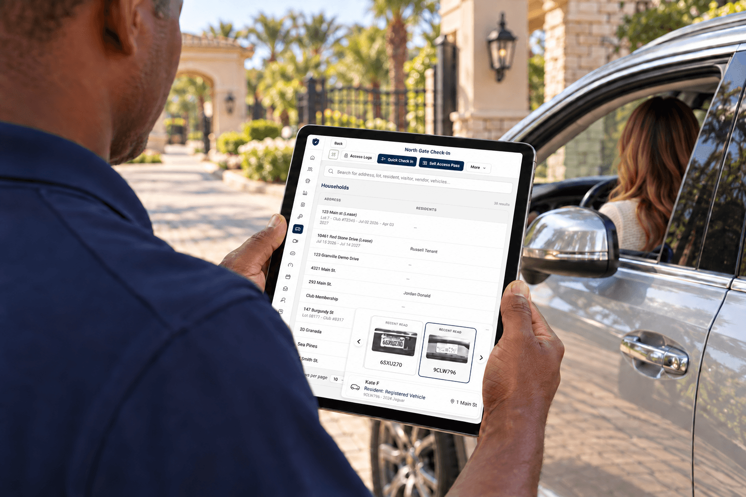 Over-the-shoulder view of a guard using GoAccess on a tablet to check in a driver at a community entrance